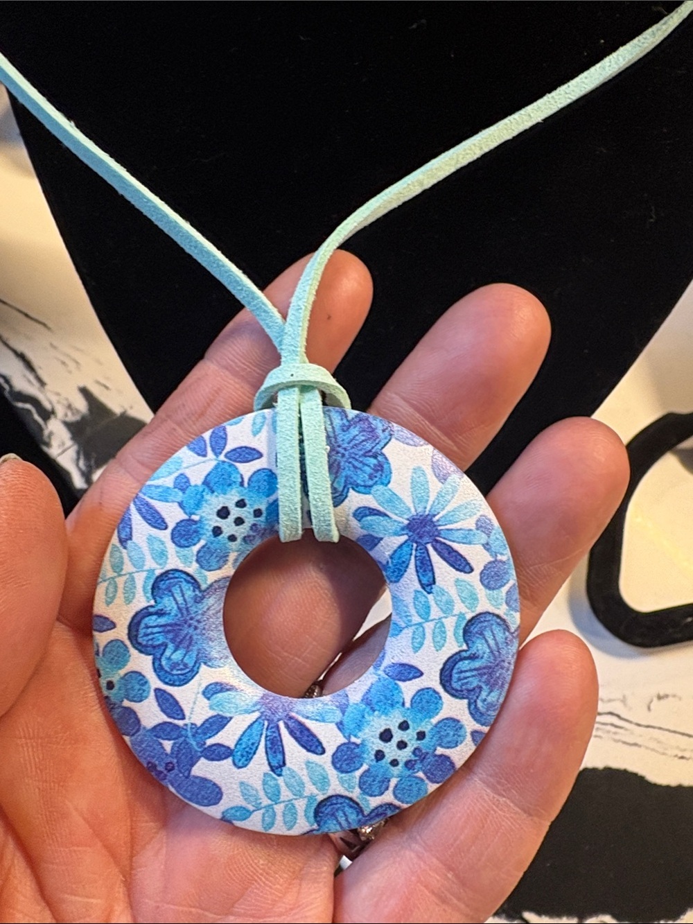 Blue Floral Donut Pendant Necklace on Aqua Suede Cord along with gold earrings - Picture 2 of 3